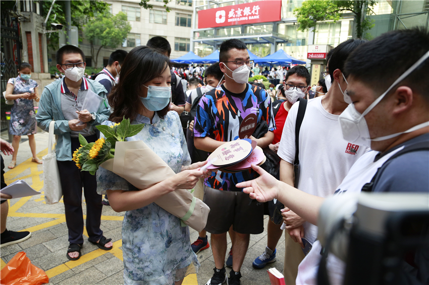 陪同考生一起的老師手捧向日葵寓意一舉“奪魁”。龔莎攝?