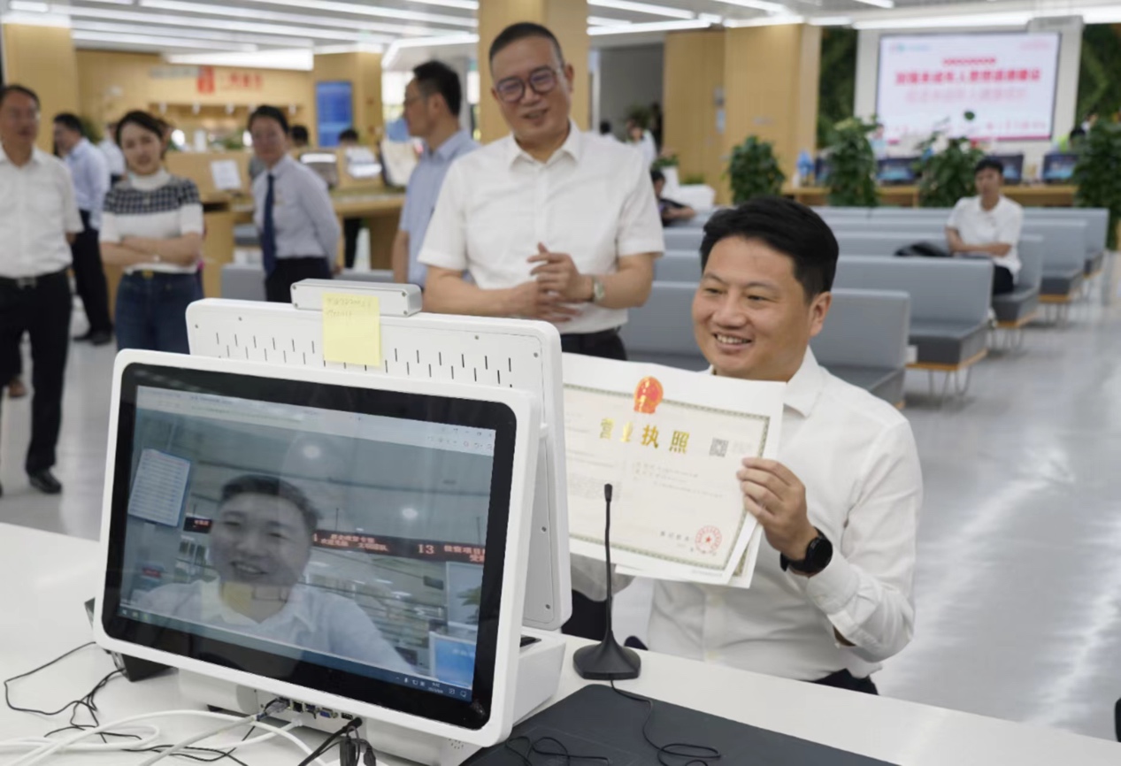 普陀區(qū)委書記姜冬冬為企業(yè)遠(yuǎn)程辦理營(yíng)業(yè)執(zhí)照。普陀區(qū)委宣傳部供圖