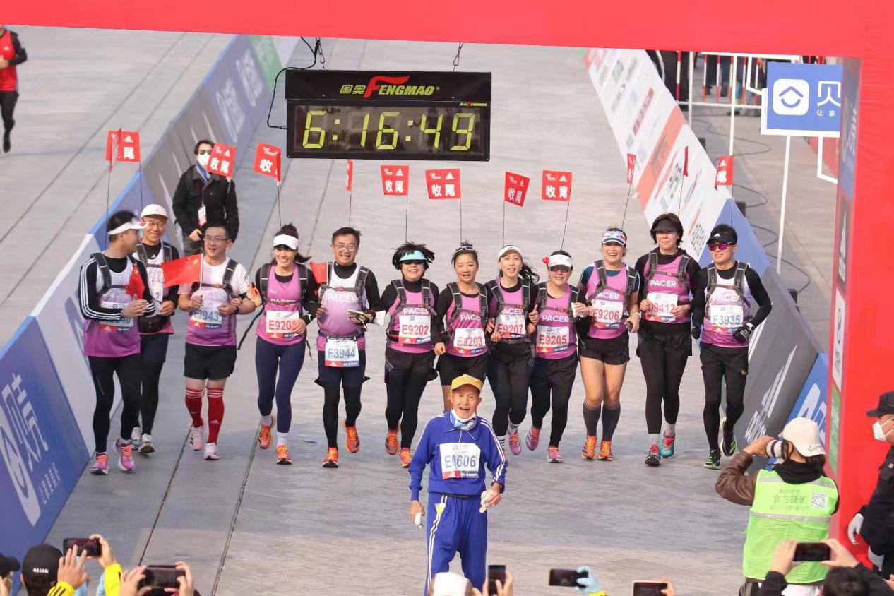 2022年北京馬拉松，唐維紅等“關(guān)門兔”陪同86歲跑者張順完賽。北京馬拉松組委會供圖
