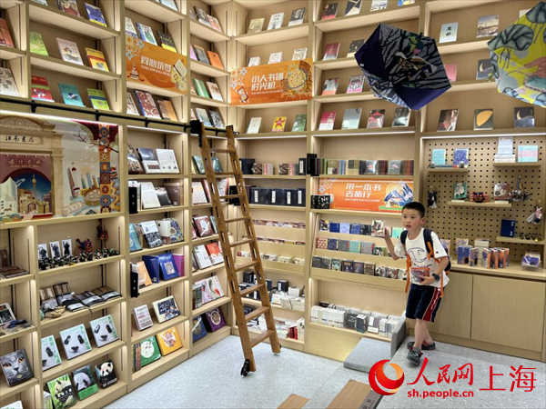 孩子在店內(nèi)向朋友介紹書。人民網(wǎng)記者 王文娟攝