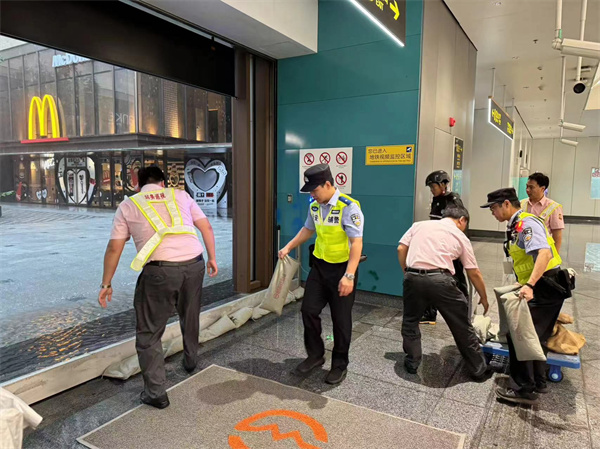 軌道公交總隊徐家匯站治安派出所民警、輔警會同車站工作人員在上海南站站9號口鋪設(shè)擋水板及阻水沙袋防止雨水倒灌。