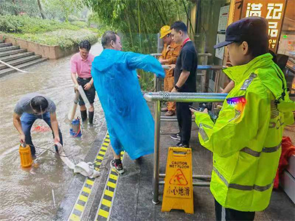 軌道公交總隊人民廣場站治安派出所民警在人民廣場站17號口外雨水積壓處組織車站工作人員抽水防止倒灌。