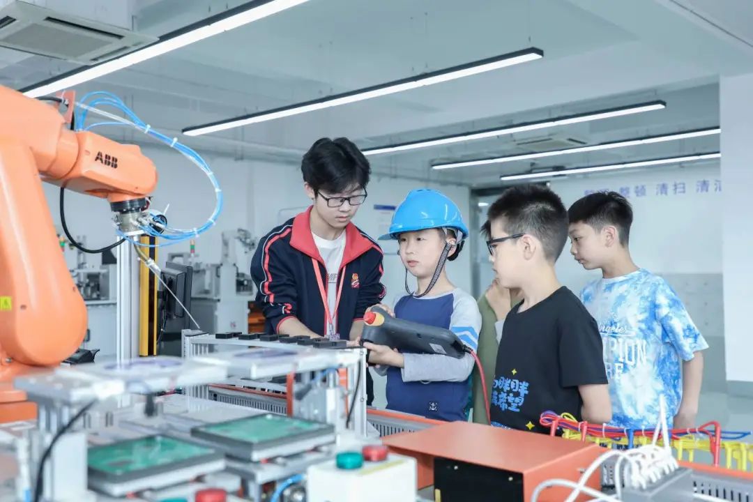 上海市工業(yè)技術(shù)學(xué)校的工業(yè)機器人項目，吸引了參加職業(yè)體驗日活動的小學(xué)生。